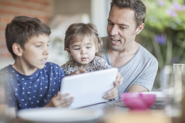 Father and his children looking together at digital tablet - ZEF008745