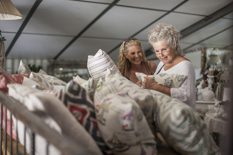Two women shopping for pillows in vintage store stock photo