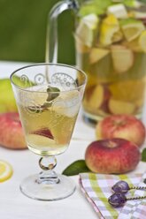 Peach iced tea in carafe, lemon, ice, mint leaves and peaches - YFF000551