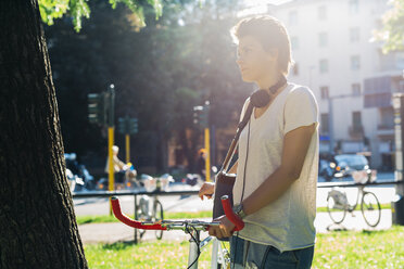 Junge Frau mit Fahrrad im Park - GIOF001243