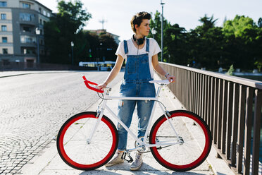 Junge Frau mit Fahrrad auf Brücke - GIOF001245