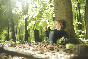 Girl in forest examining leaves - SBOF000153