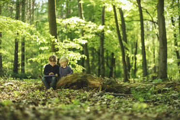 Bruder und Schwester im Wald mit digitalem Tablet - SBOF000163