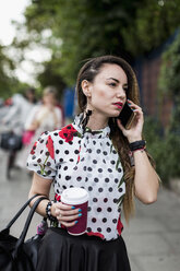 Porträt einer jungen Frau mit Kaffee zum Telefonieren mit Smartphone - MAUF000664