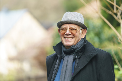 Porträt einer glücklichen Seniorin mit Hut und Brille, lizenzfreies Stockfoto