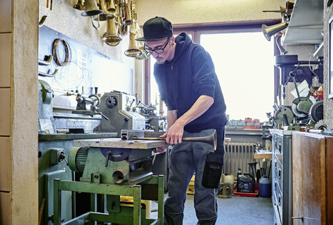 Instrumentenbauer baut Trompete in der Werkstatt, lizenzfreies Stockfoto