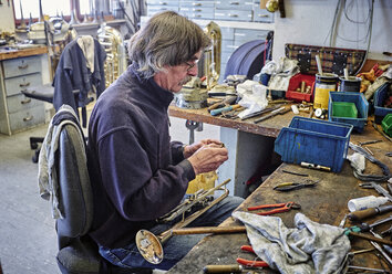 Instrumentenbauer bei der Reparatur einer Trompete in der Werkstatt - DIKF000193
