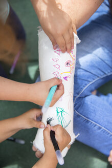 Little girls painting her mother's plaster arm - ERLF000182