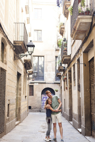 Glückliches verliebtes Paar in einer Gasse stehend, lizenzfreies Stockfoto