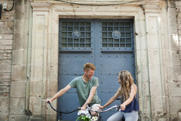 Spain, Barcelona, laughing couple with bicycles - VABF000591