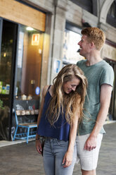 Happy couple standing in front of a coffee shop - VABF000610