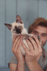 Young man holding kitten, close-up - RTBF000237