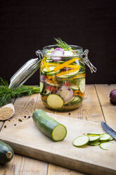 Glass of pickled courgette and bell pepper, preparation with different spices - LVF004981