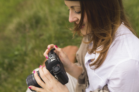 Frau mit einer alten Kamera auf einer Wiese, lizenzfreies Stockfoto
