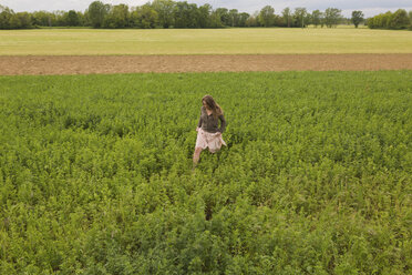 Frau geht auf einem Feld - BOYF000447