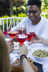 Freunde, die bei einem sommerlichen Abendessen mit Lambrusco-Wein anstoßen - ABZF000726