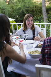 Frau lächelt während eines Sommeressens - ABZF000735