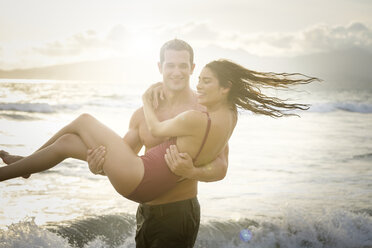 Man carrying his girlfriend at seafront - ABAF002056