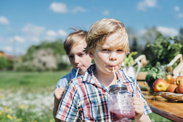 Zwei Jungen trinken im Freien aus Gläsern - MJF001902