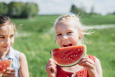 Zwei Mädchen essen im Freien Scheiben von Wassermelonen - MJF001906