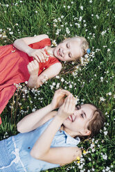 Two happy girls lying in flower meadow - MJF001924