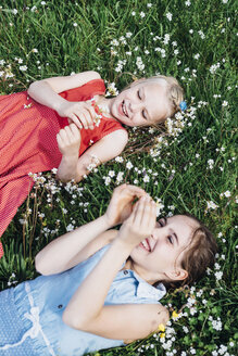 Zwei glückliche Mädchen auf einer Blumenwiese - MJF001924