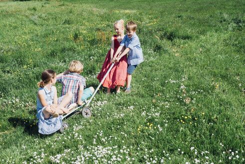 Kinder mit Wagen spielen auf der Wiese - MJF001927