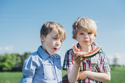 Zwei Jungen essen im Freien Wassermelone, lizenzfreies Stockfoto