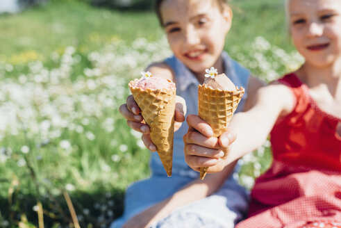 Two girls in meadow holding ice cream cones - MJF001947