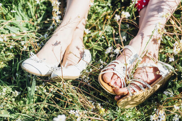 Close-up of feet of two girls in meadow - MJF001949