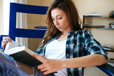 Junge Frau liest zu Hause ein Buch - KIJF000495