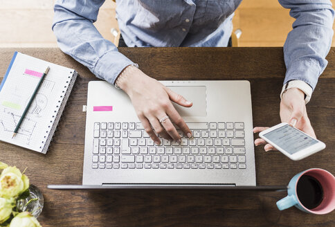 Teenage girl with celll phone and laptop at desk - UUF007824