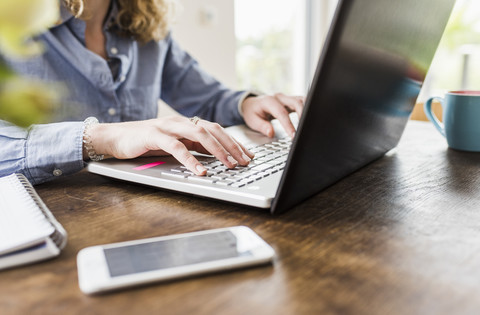 Teenage girl using laptop at desk stock photo