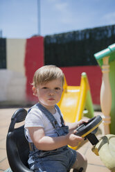 Porträt eines Kleinkindes, das auf einem Bobbycar sitzt - RAEF001227