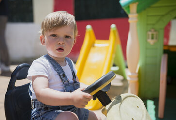 Portrait of toddler sitting on bobby car - RAEF001228