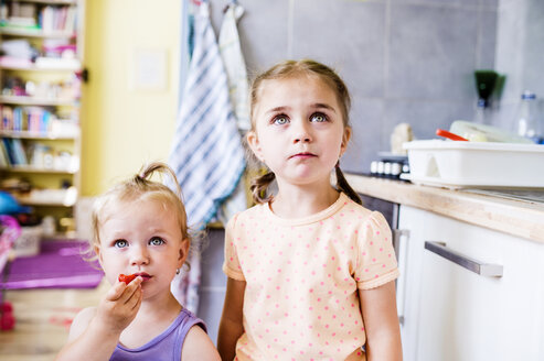 Zwei kleine Schwestern stehen in der Küche und schauen nach oben - HAPF000501