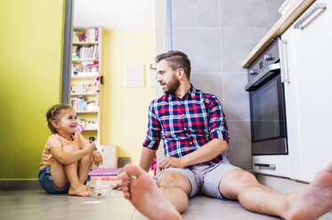 Vater und Tochter essen Tomaten in der Küche - HAPF000504