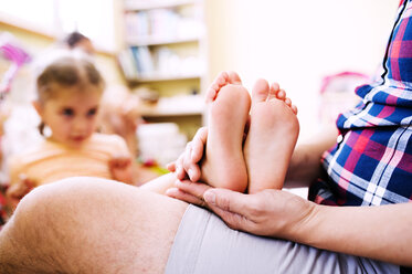 Kleine Mädchen setzen ihre nackten Füße auf den Schoß des Vaters - HAPF000514