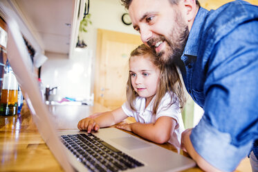 Vater und Tochter benutzen Laptop zu Hause - HAPF000530