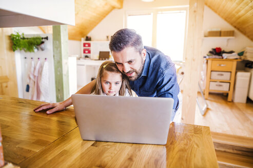 Vater und Tochter benutzen Laptop zu Hause - HAPF000531