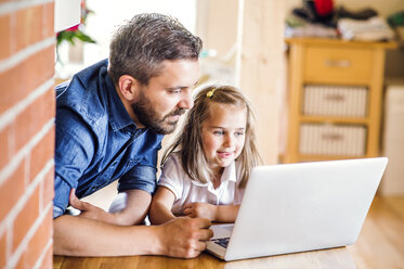 Vater und Tochter benutzen Laptop zu Hause - HAPF000533