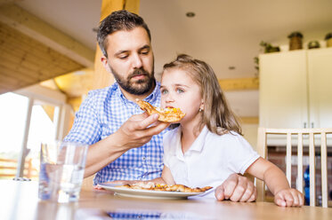 Father feeding his little daughter with pizza - HAPF000543