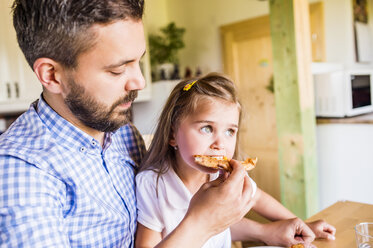 Father feeding his little daughter with pizza - HAPF000544