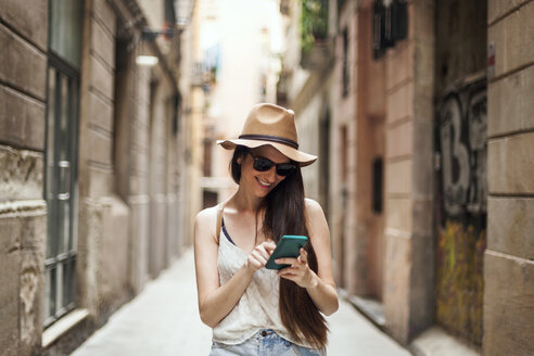 Junger Tourist auf Entdeckungstour durch die Straßen von Barcelona, mit Handy - VABF000637