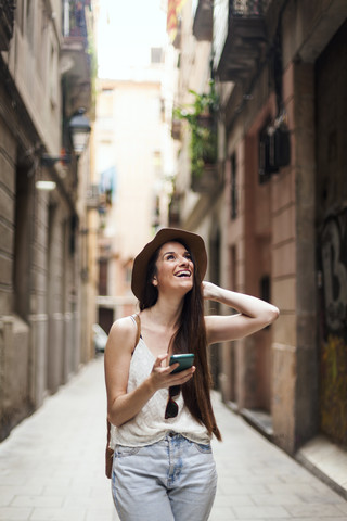 Junger Tourist auf Entdeckungstour durch die Straßen von Barcelona, mit Handy, lizenzfreies Stockfoto