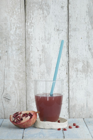 Ein Glas Granatapfelsaft und ein halber Granatapfel, lizenzfreies Stockfoto