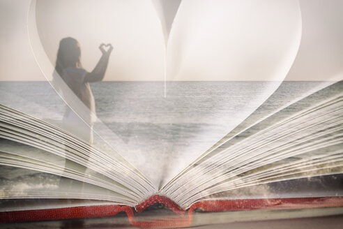 Spanien, Formentera, Frau formt ein Herz am Strand, offenes Buch - CMF000507