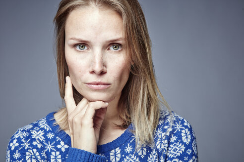 Portrait of serious blond woman with hand on chin - RHF001643