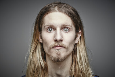 Portrait of starring young man with long blond hair and beard - RHF001657