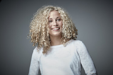 Portrait of happy blond woman with curly hair - RHF001663